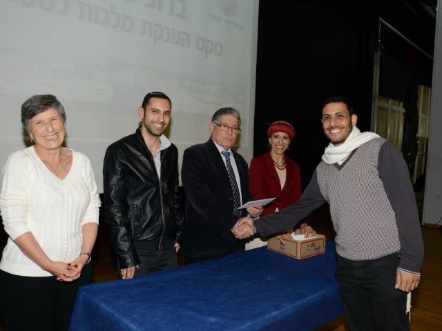 מקבלים מלגות, ראש העיר וחברי הוועדה מעניקים מלגה לסטודנט. צילום ארכיון